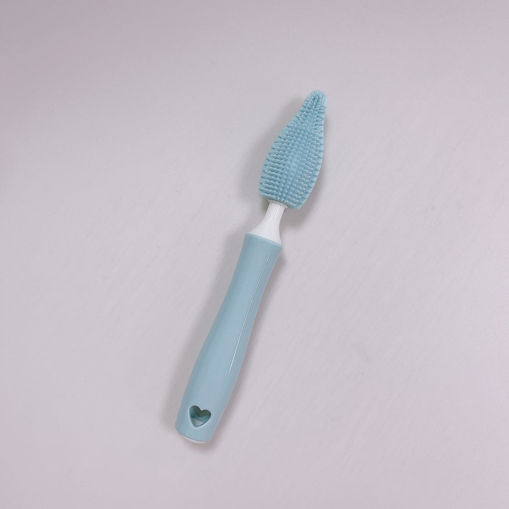 Blue cleaning brush with textured head on a light gray background