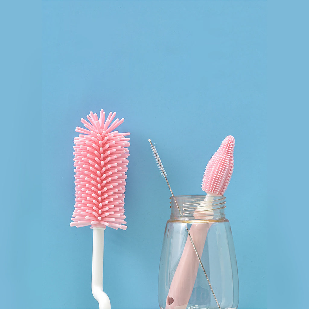 Pink bottle cleaning brush and straw on a blue background