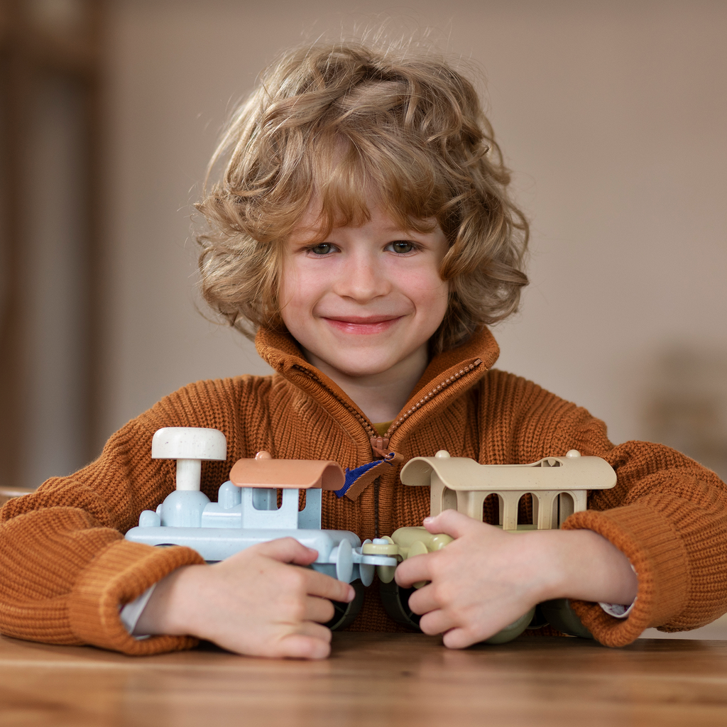 Child holding a toy train toys and games