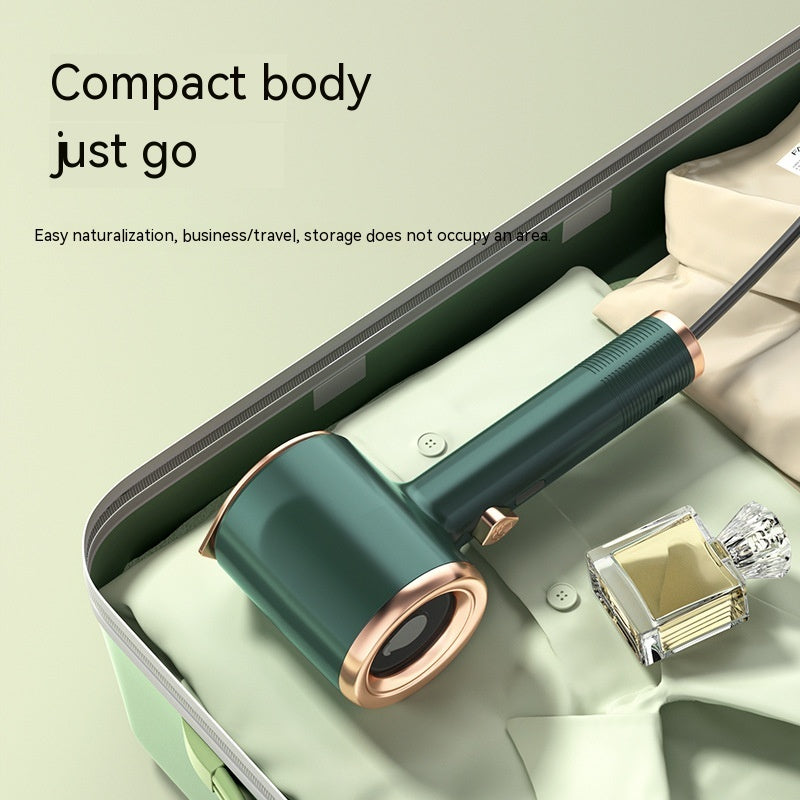 Green and rose gold Handheld garment steamer on a light green surface with text about compact design.